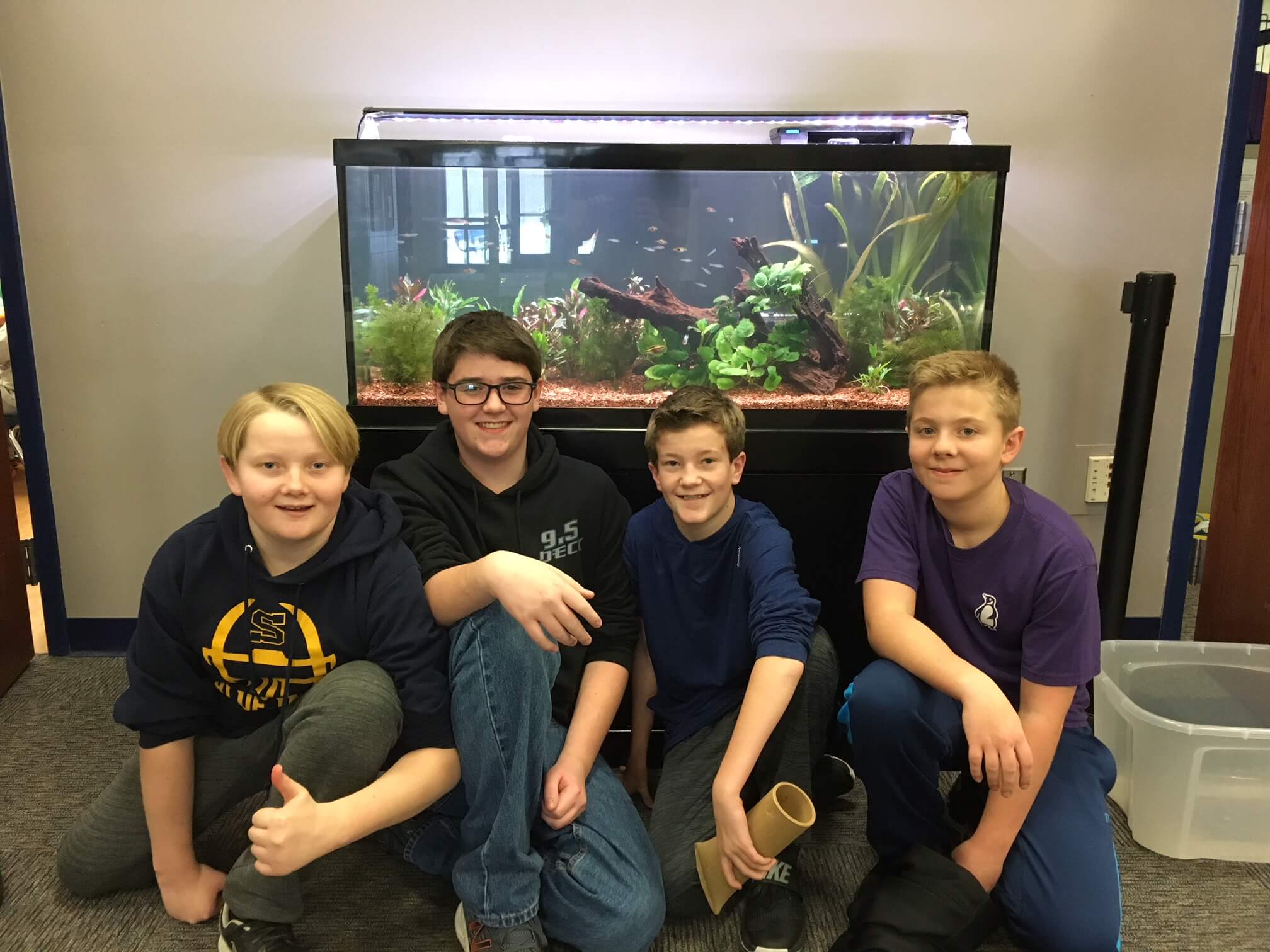 Students posing in front of aquarium