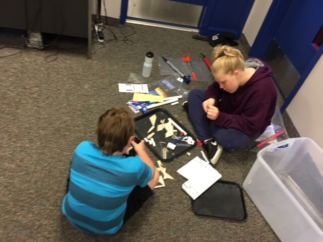 Two students building rockets.